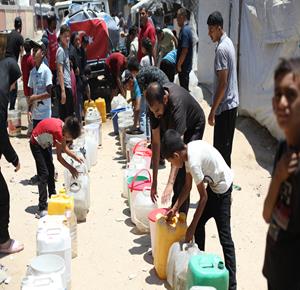 نازحون يتجمعون للحصول على المياه من صهريج توزيع في مخيم النصيرات وسط قطاع غزة، في ظل ارتفاع درجات الحرارة واستمرار أزمة المياه، مع تراجع كميات المياه الواصلة إلى المخيمات بسبب نقص الوقود والصعوبات في تشغيل شاحنات نقل المياه.